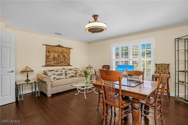 dining space featuring crown molding and dark wood-type flooring