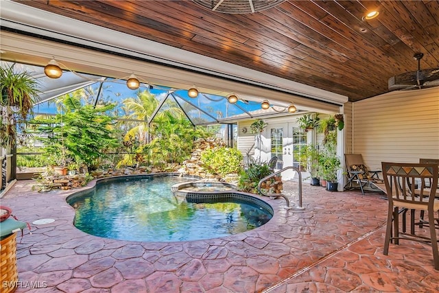 view of swimming pool with a patio area, an in ground hot tub, and glass enclosure