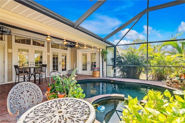 view of swimming pool with glass enclosure, an in ground hot tub, french doors, and a patio area