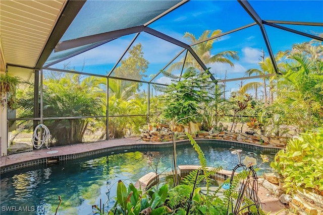 view of swimming pool featuring glass enclosure