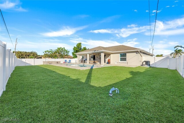 back of house with a lawn, a patio area, and cooling unit