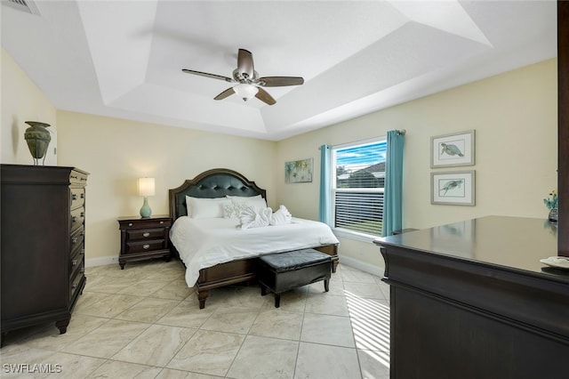 bedroom with ceiling fan and a raised ceiling