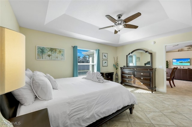 bedroom with ceiling fan and a raised ceiling