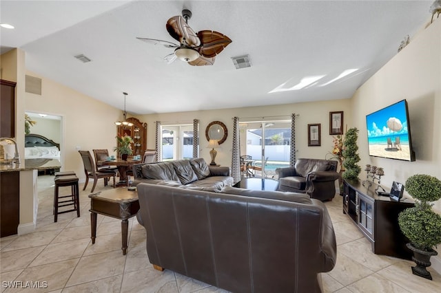 living room featuring ceiling fan, lofted ceiling, and light tile patterned floors