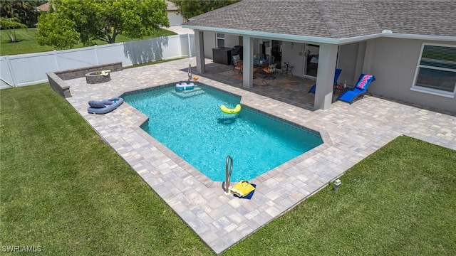 view of pool featuring a yard, a patio, and an outdoor fire pit