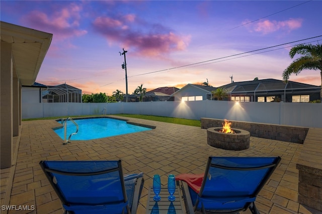 pool at dusk featuring a patio and an outdoor fire pit