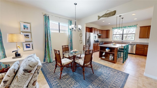 dining area with a chandelier, light tile patterned floors, and a healthy amount of sunlight