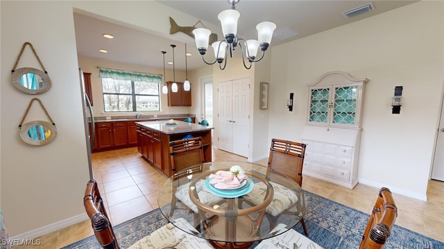 tiled dining space with a chandelier