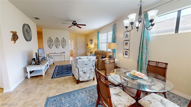 tiled dining area featuring ceiling fan with notable chandelier