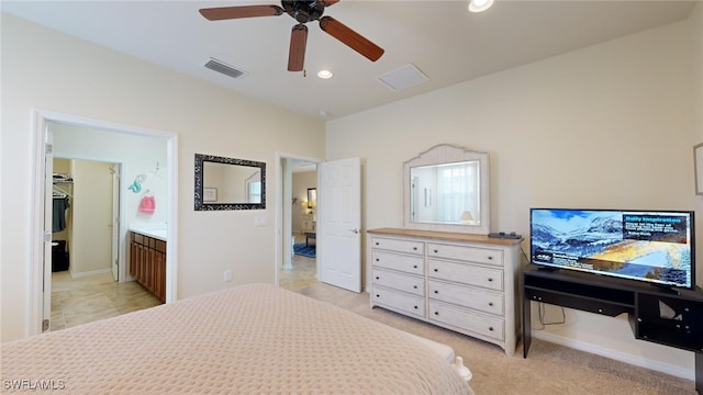 carpeted bedroom with ensuite bath and ceiling fan