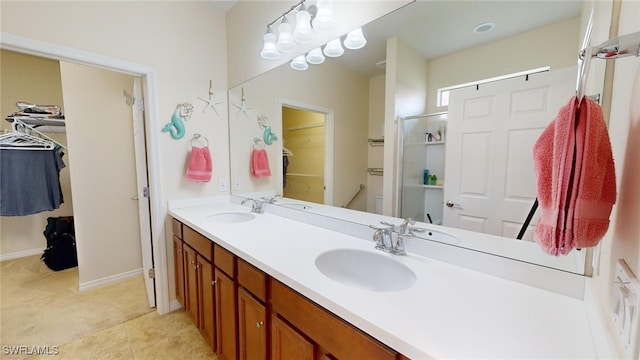 bathroom featuring tile patterned floors, vanity, and a shower with shower door