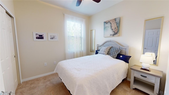 carpeted bedroom featuring ceiling fan and a closet