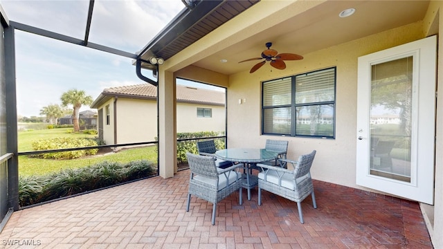 sunroom / solarium featuring ceiling fan and plenty of natural light