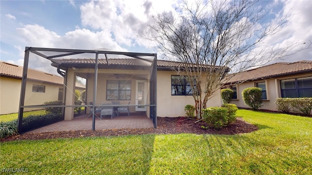 back of property with a lawn, a patio area, and ceiling fan