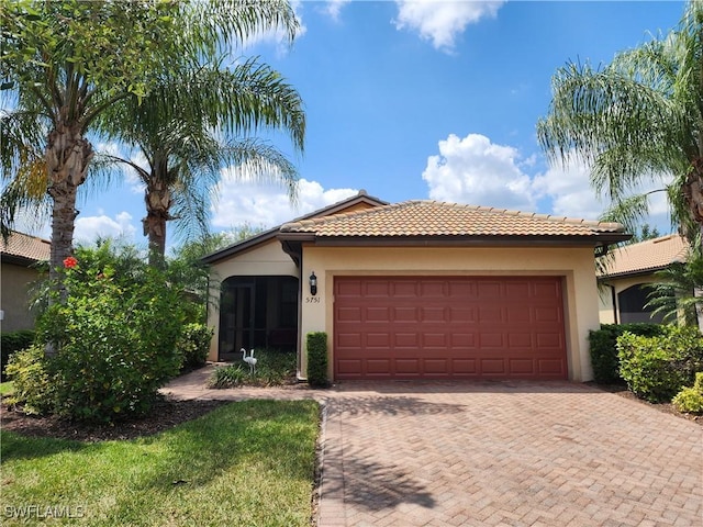 view of front of house featuring stucco siding, a garage, a tiled roof, and decorative driveway