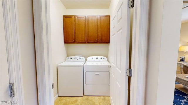 laundry area featuring washer and clothes dryer and cabinets