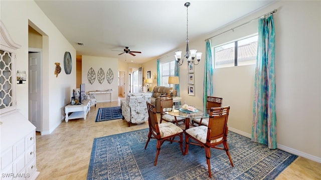 dining area with ceiling fan with notable chandelier