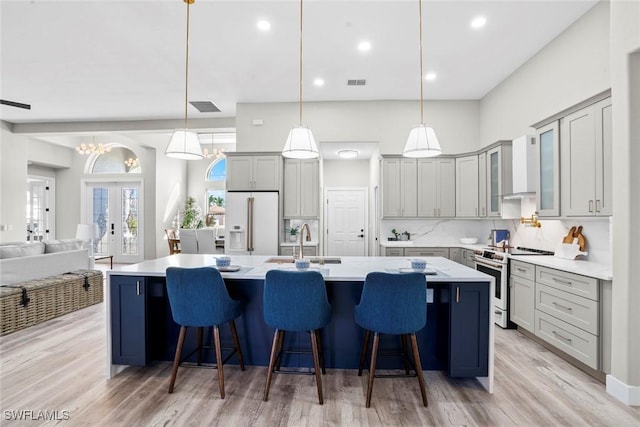 kitchen with pendant lighting, a large island, a kitchen breakfast bar, and white appliances