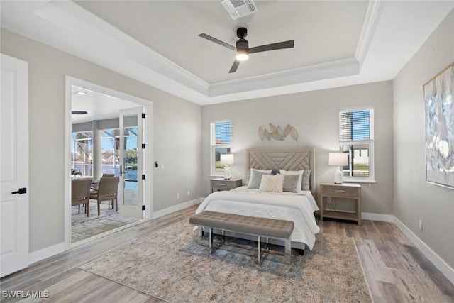 bedroom featuring hardwood / wood-style floors, access to outside, and multiple windows