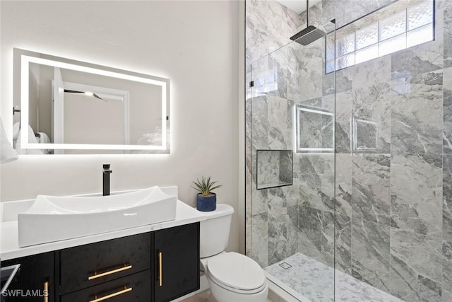 bathroom featuring tiled shower, vanity, and toilet