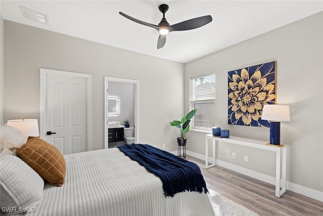 bedroom with ceiling fan, connected bathroom, and light hardwood / wood-style flooring