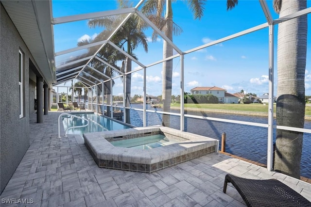 view of pool with glass enclosure, a water view, an in ground hot tub, and a patio