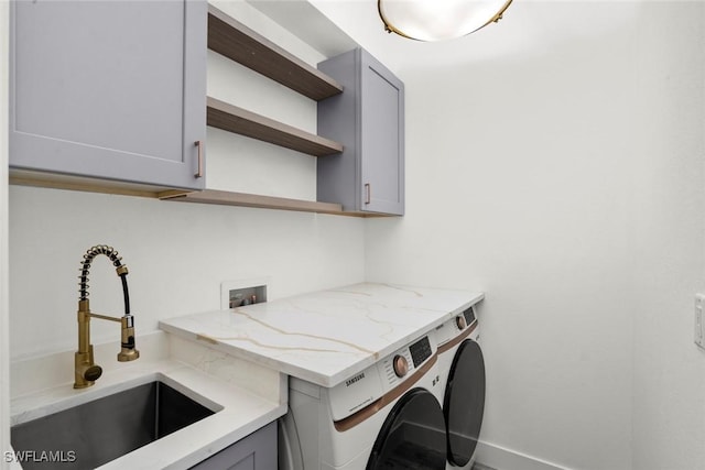 laundry room featuring cabinets, separate washer and dryer, and sink