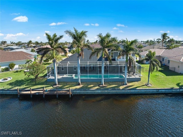 rear view of property with a yard, a water view, and a lanai