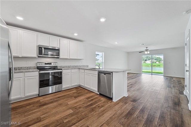 kitchen featuring a wealth of natural light, dark hardwood / wood-style flooring, white cabinetry, and appliances with stainless steel finishes