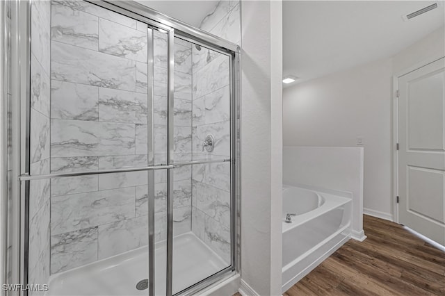 bathroom featuring plus walk in shower and wood-type flooring