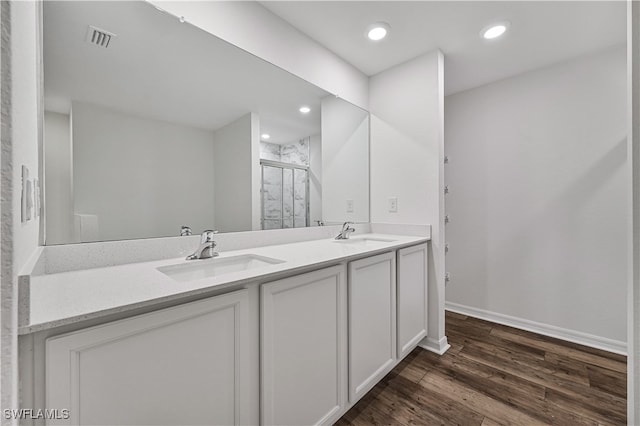 bathroom with a shower with door, vanity, and wood-type flooring