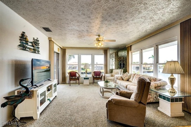 carpeted living room with ceiling fan, plenty of natural light, and a textured ceiling