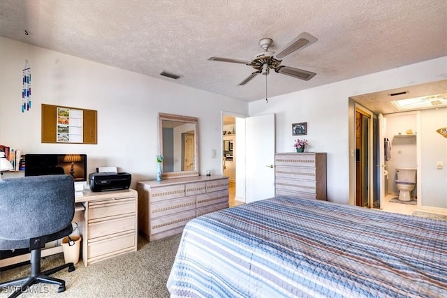 carpeted bedroom with ceiling fan, ensuite bathroom, and a textured ceiling