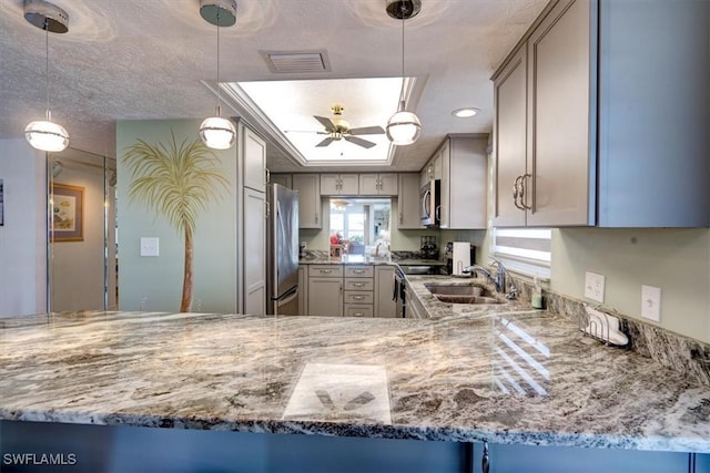 kitchen with ceiling fan, sink, stainless steel appliances, and decorative light fixtures