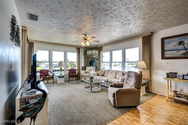 living room featuring a textured ceiling, carpet floors, and ceiling fan