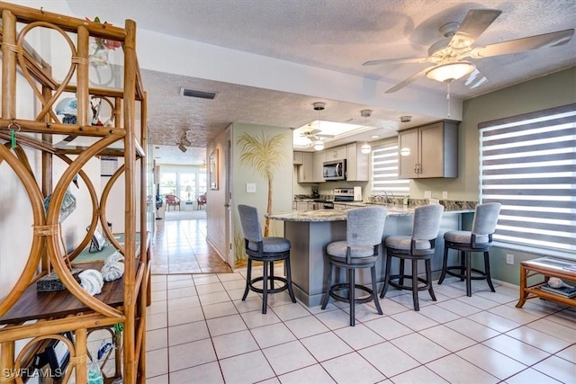 kitchen with kitchen peninsula, a textured ceiling, and stainless steel appliances