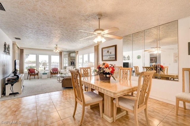 tiled dining area with ceiling fan and a textured ceiling