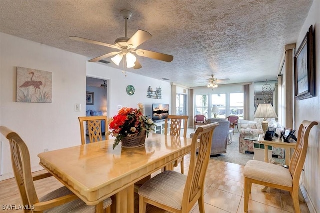 tiled dining room featuring ceiling fan and a textured ceiling