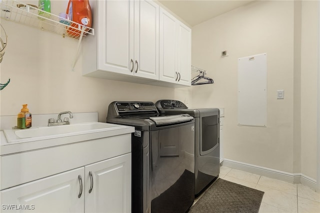 clothes washing area featuring sink, light tile patterned floors, cabinets, and independent washer and dryer