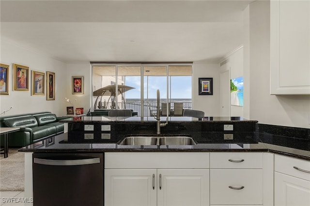 kitchen with sink, stainless steel dishwasher, kitchen peninsula, dark stone counters, and white cabinets