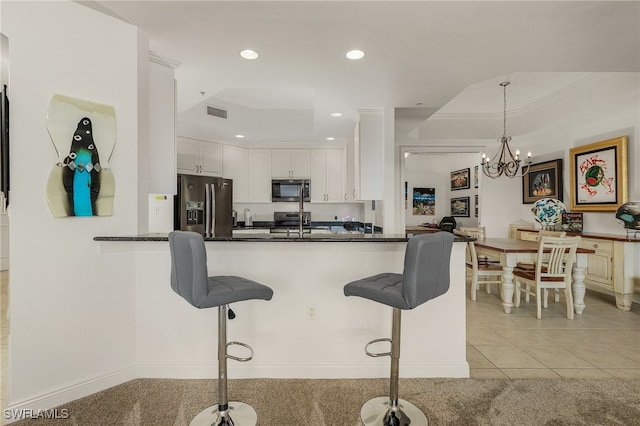 kitchen featuring pendant lighting, an inviting chandelier, white cabinets, kitchen peninsula, and stainless steel appliances