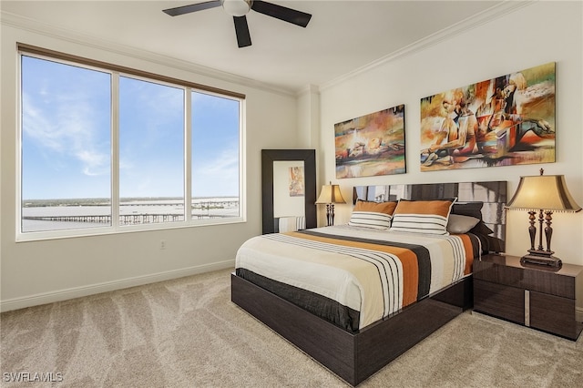 carpeted bedroom featuring ceiling fan and crown molding