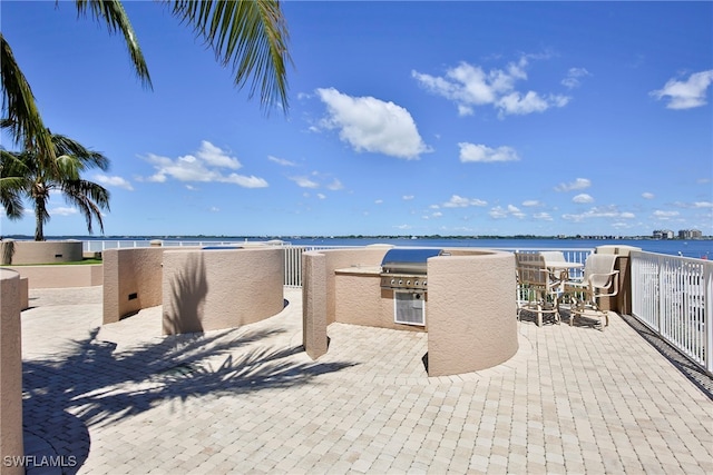 view of patio / terrace with a water view and an outdoor kitchen