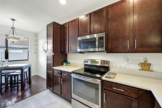 kitchen featuring hanging light fixtures, stainless steel appliances, light hardwood / wood-style flooring, a notable chandelier, and dark brown cabinets