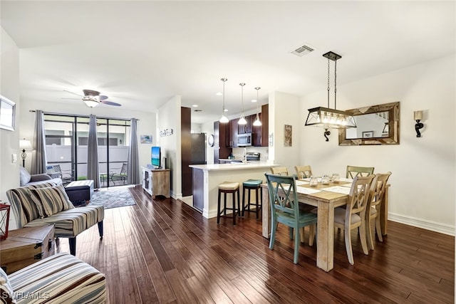 dining space with ceiling fan and dark wood-type flooring