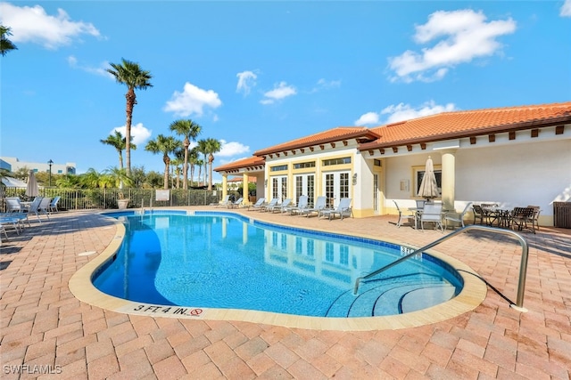 view of swimming pool with french doors and a patio area