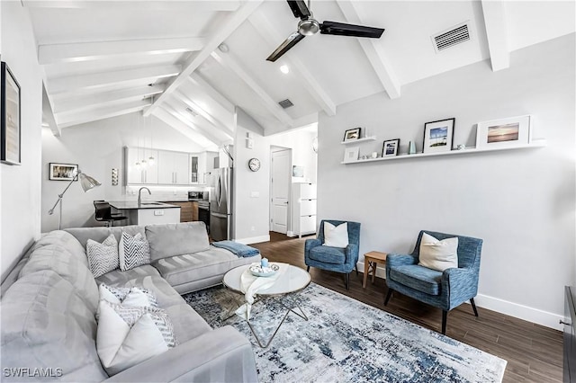 living room featuring vaulted ceiling with beams, ceiling fan, dark wood-type flooring, and sink