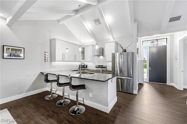 kitchen featuring kitchen peninsula, dark hardwood / wood-style flooring, stainless steel appliances, sink, and white cabinets