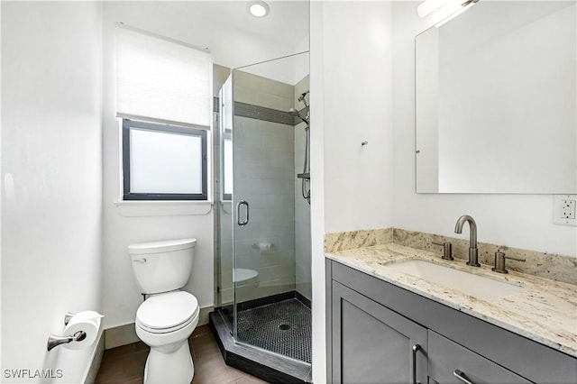 bathroom featuring vanity, toilet, and an enclosed shower