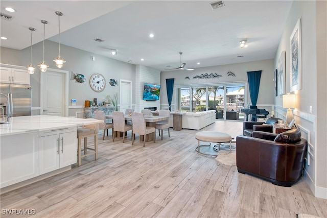 living room featuring ceiling fan and light hardwood / wood-style floors